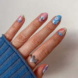 Hand laat blauwe roze nagelstickers zien met vrolijke funky print