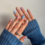 Twee handen laten blauwe roze nagelstickers zien met vrolijke funky print