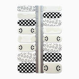 Nagelstickers met zwart-witte blokjes en smileys op witte achtergrond