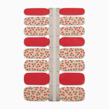 Nagelstickers met rood en beige en een druk kersenpatroon op een witte achtergrond