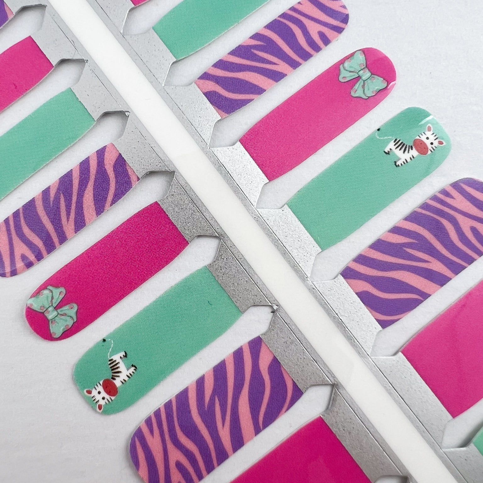 Detailfoto van nagelstickers voor kids met zebra in verschillende kleuren op witte achtergrond