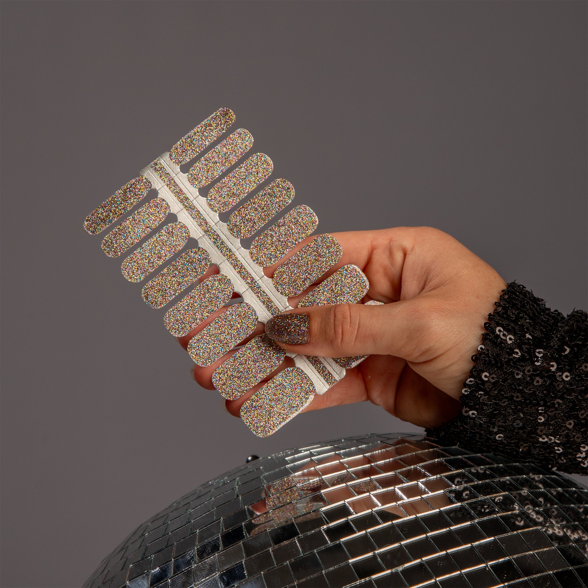 Nagelsticker met gekleurde glitters met hand en discobal