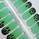 Detailfoto van nagelstickers met witte en groene vlammen op witte achtergrond