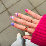 Hand laat nagelstickers zien met gekleurde marmer en roze trui