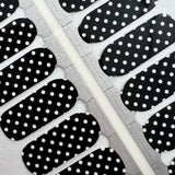 Detailfoto van zwarte nagelstickers met witte stippen