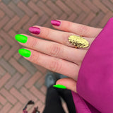 Hand met groene en roze nagellak met roze jas en gouden ring
