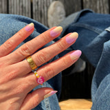 Lifestyle foto van nagelstickers met een lila ombre met geel en gouden ringen
