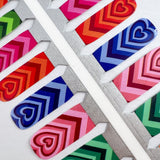 Detailfoto van nagelstickers met hartjes in verschillende kleuren op witte achtergrond