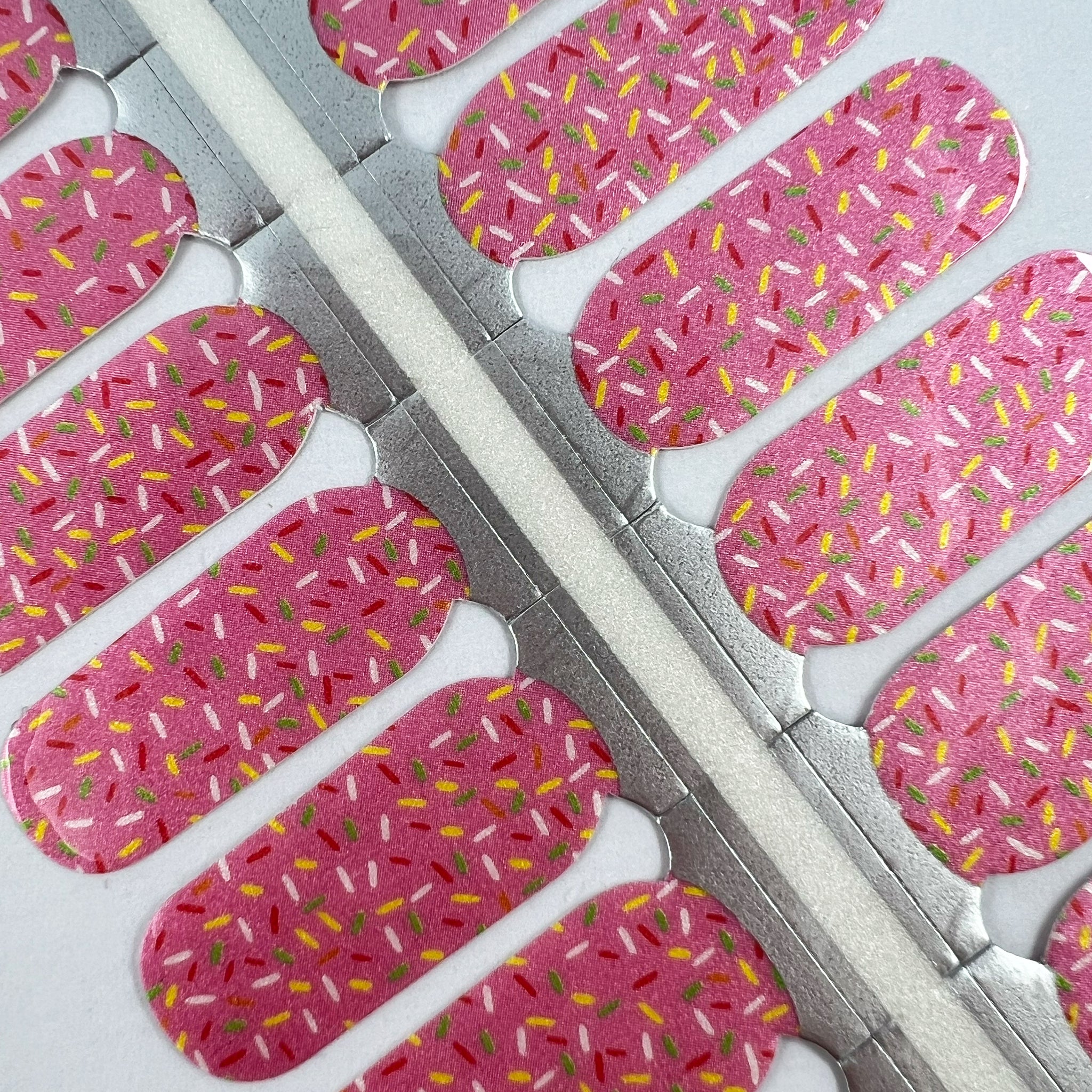 Detailfoto van nagelstickers met glimmend roze en confetti
