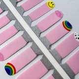 Detailfoto van nagelstickers voor kids met lichtroze, smileys en regenbogen op witte achtergrond