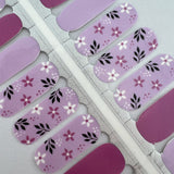 Detailfoto van nagelsticker met lila en bloemen op witte achtergrond