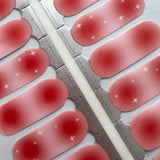 Detail foto van nagelstickers met roze aura en witte twinkels op witte achtergrond