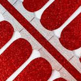 Detailfoto van nagelstickers met rode glitters op witte achtergrond