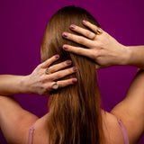 Model in studio toont roze nagelstickers met glitters op haar nagels met handen in haar