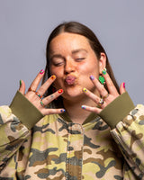 Model houdt handen voor gezicht met camouflage jasje