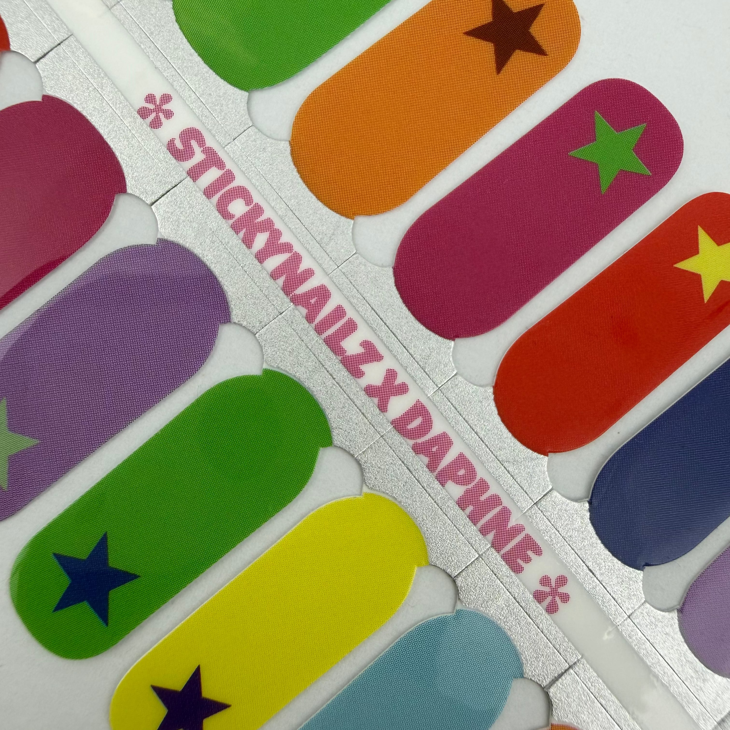 detail foto van nagelstickers met kleuren en sterren op witte achtergrond
