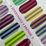 Detail foto van nagelstickers met kleurrijke strepen op witte achtergrond