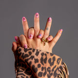 handen laten nagelstickers zien met roze iconen en panterprint jas met franjes